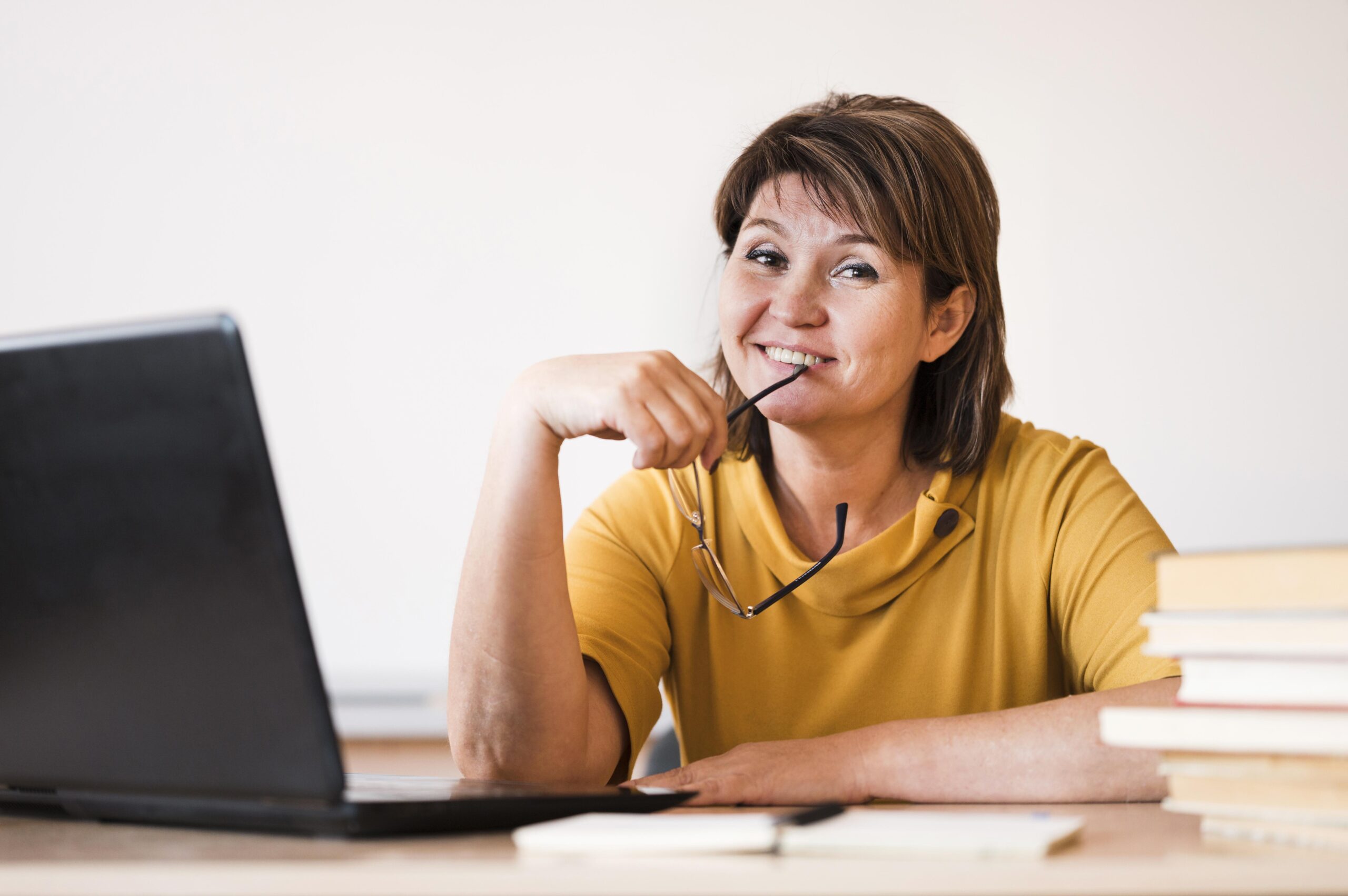 female-teacher-with-laptop-sitting-desk