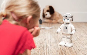 Meisje kijkt naar kleine witte robot