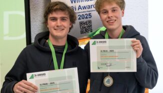 Twee jonge winnaars houden trots hun certificaat omhoog na het winnen van de 3i Award 2025 voor informatica, met medaille en achtergrondbord met logo's.